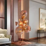 Luxury modern floor lamp with rose gold glass orbs – artistic designer lighting fixture for contemporary interiors, ambient glow decor piece for living room or hotel lobby.