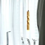 Modern gold twisted pendant light, brass finish, cylindrical hanging lamp.